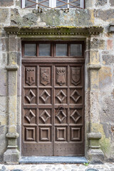 Old rustic wooden door, in the town of Salers in Auvergne, France