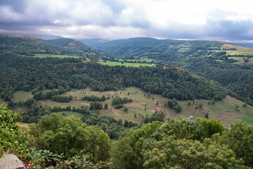 Country landscape in Auvergne, France with mountains, forests and fields for agriculture
