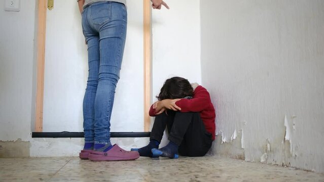 domestic violence. little boy with bruises and abrasions autistic on her face punished in the corner crying tears. domestic child abuse fear concept. child is punished and beaten afraid of fear