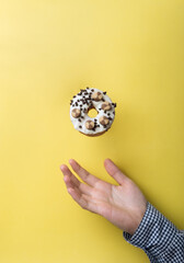 Fototapeta na wymiar Delicious Donut Levitating On A Yellow Background. Creative Photography