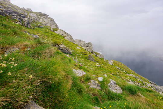 danger and beauty if romanian carpathians. rocky steep slopes in mist. overcast sky