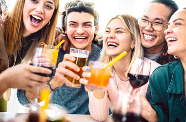 Diverse friends toasting fancy mixed cocktails - Young people having fun together drinking beer and wine at happy hour - Life style party time concept on vintage filter - Focus on right blond woman