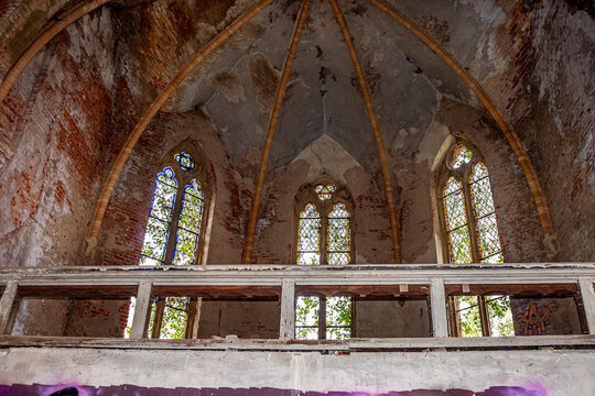 Ruine einer alten Kirche mit Graffiti und teilweise zugewachsen