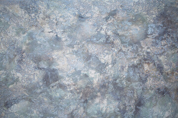 Gray background of decorative plaster with abstract spots. Unusual silver wall texture with beautiful patterns, creative surface background. Dressing coating for building cladding.