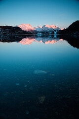 Mountain reflection in a lake at sunset. Beautiful winter landscape.