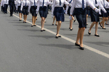 Fototapeta na wymiar School students in uniform marching on parade