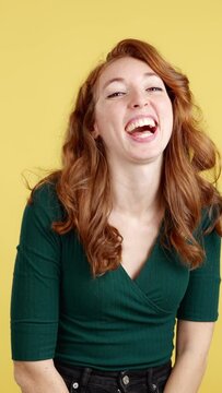 Happy redheaded woman laughing and looking at camera