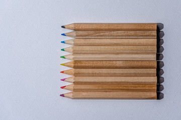 Fototapeta premium Pile of colorful wooden pencils on white background