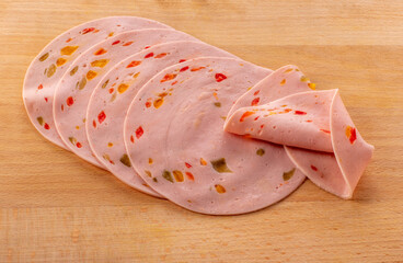 Paprika lyoner sausage slices with red bell pepper, on wooden cutting board © framarzo
