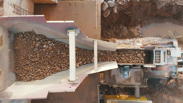 jaw crusher plant with belt conveyor puts crushing stones and screening sand. Crushing concrete into gravel. Crushing complex in open pit mining