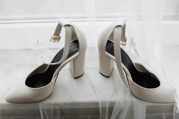 White elegant shoes. A pair of classic white shoes standing on a window sill on a white background. Fashion. Style. Wedding photo - Powered by Adobe