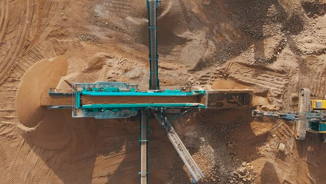 Sand Making Plant and Belt conveyor in mining quarry. Mining truck unload sand in stone crushing plant. Haul truck in opencast. Sand crushing plant. Extracting rock in Open-pit mining, aerial view.
