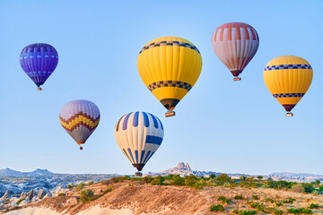 Obraz premium Landscape of colorful flying hot air balloons in Anatolia, Kapadokya at sunrise. National park in Nevsehir, Goreme