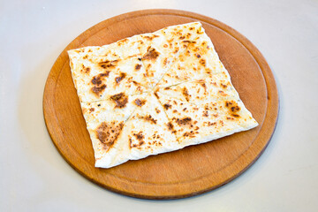 Freshly baked appetizing Turkish tortillas - Gozleme with spinach, cheese  on a wooden board. Space for text. Shallow depth of  field. Handmade Turkish traditional pastries.