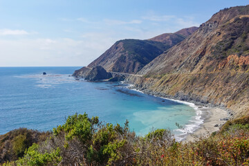 Panoramic view of Bixby Creek Bridge along rugged coastline of Big Sur with Santa Lucia Mountains along famous Highway 1, Monterey county, California, USA, America. Road trip to hidden deserted beach