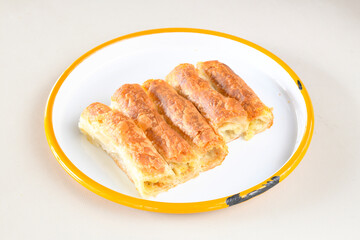 Turkish style meat stuffed filo dough borek served kol boregi. Cheese and minced pie are sliced on a marble background. Turkish name: Kol Boregi, ispanakli, kiymali, Su Boregi