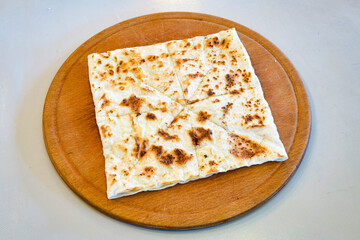 Freshly baked appetizing Turkish tortillas - Gozleme with spinach, cheese  on a wooden board. Space for text. Shallow depth of  field. Handmade Turkish traditional pastries.