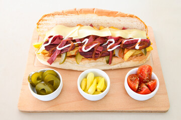 Close-up shot of Izmir's famous Turkish Traditional Kumru Sandwich, Çeşme Kumru , ingredients ready to eat salami, sucuk , tomato, cheddar cheese and fried cheese. Yengen eritme karisik sandvic.