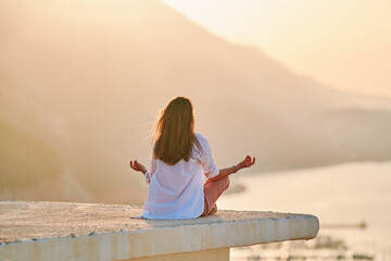 Female sit on top and meditate at sunset time. Relief stress, retreat and healthy minds