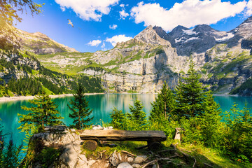 Famous Oeschinensee with Bluemlisalp mountain on a sunny summer day. Panorama of the azure lake Oeschinensee. Swiss alps, Kandersteg. Amazing tourquise Oeschinnensee with waterfalls, Switzerland.
