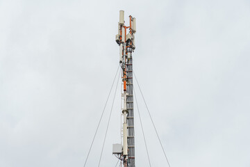 Obraz premium New GSM antennas on a tower against a blue sky for transmitting a 5g signal are dangerous. Radiation pollution of the environment through cell towers. New technologies in the field of communication.