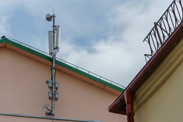 Fototapeta na wymiar New GSM antennas on the roof of a residential building in the city for transmitting a 5g signal are a danger to human health. Radiation pollution of the environment through cell towers.