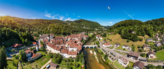 Fototapeta premium Picturesque Swiss village of Saint-Ursanne on the Doubs River, Switzerland. Village Saint-Ursanne in the district of Porrentruy in the canton of Jura, Switzerland. Saint Ursanne, Jura, Suisse