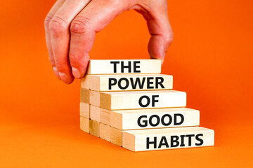 The power of good habits symbol. Concept words The power of good habits on wooden block. Beautiful orange table orange background. Businessman hand. Business power of good habits concept. Copy space.