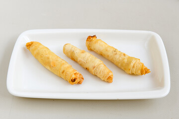 Turkish style meat stuffed filo dough borek served kol boregi. Cheese and minced pie are sliced on a marble background. Turkish name: Kol Boregi, ispanakli, kiymali, Su Boregi