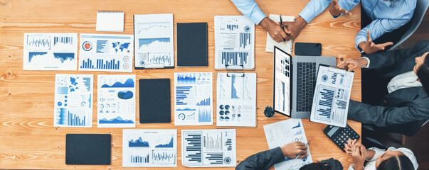 Panorama top view multiracial analyst team use BI dashboard display on laptop screen, analyzing financial data for strategic decision. Fintech analyzes marketing indicators. Concord
