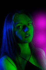 face of girl on a dark background with colored lights - art portrait