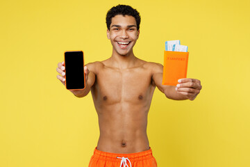 Traveler man wear orange shorts swimsuit hold passport ticket use show mobile cell phone isolated...