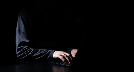 Computer hacker in black mask and hoodie. Obscured dark face. Data thief, internet fraud, cyber...