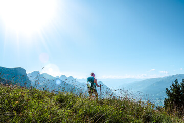 Obraz premium Young woman enjoys the view from a vantage point on the Walensee in the morning. Schnürliweg, Walensee, St. Gallen, Switzerland, Europe.