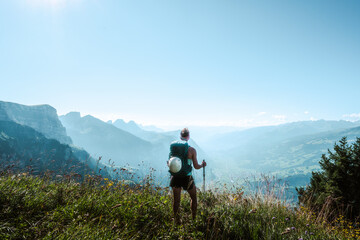 Athletic woman enjoys the view from a vantage point on the Walensee in the morning. Schnürliweg,...