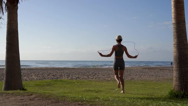 girl goes in for sports on the seashore jumping rope