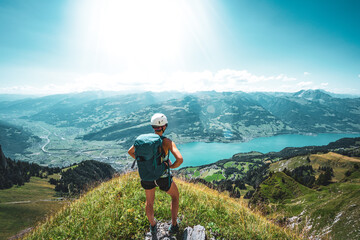 Athletic woman enjoys the panoramic view on Walensee from a beautiful view point next to the hike trail. Schnürliweg, Walensee, St. Gallen, Switzerland, Europe. - obrazy, fototapety, plakaty