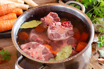 Beef bones to make homemade bone broth for a healthy diet on the table. Saucepan with bone broth