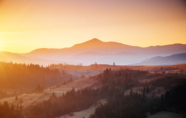 Magical sunset in the mountains with warm rays of the sun. Carpathian mountains, Ukraine, Europe.