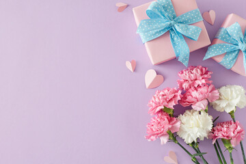 Fototapeta na wymiar Tenderness and love for mom concept. Top view photo of gift boxes bunch of carnation flowers and paper hearts on light violet background. Flat lay with for text or greeting message