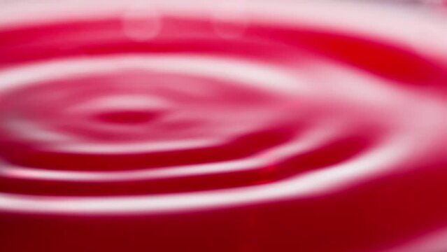 Slowly falling drops of wine. Falling drop of wine in slow motion. Wine drop falling into red wine. Close-up shot