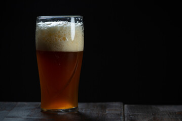 A glass of delicious craft beer served on an authentic beer glass, to be used as a background