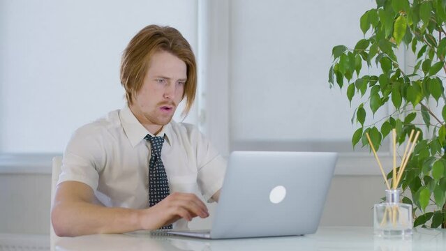 red-haired young male worker in the office.abruptly closes the laptop.fright 