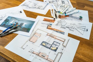 Interior design sketching, designer's desk with computer, sketches, prints, and drawing tools