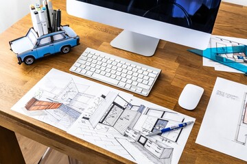 Interior design sketching, designer's desk with computer, sketches, prints, and drawing tools