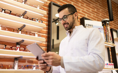 Confident specialist with tablet in optical store