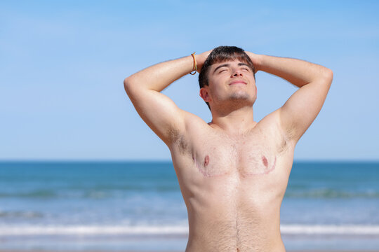 Glad shirtless gay on beach