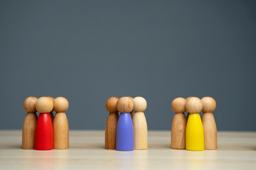 Groups of multicolored wooden people on a gray background. The concept of market segmentation....