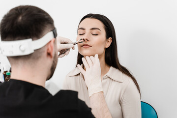 Consultation with ENT doctor. Otolaryngologist examines girl nose before procedure of endoscopy of...