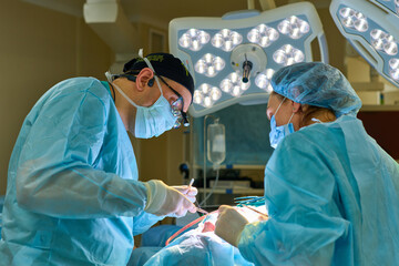 plastic surgeon operates on a patient in the operating room